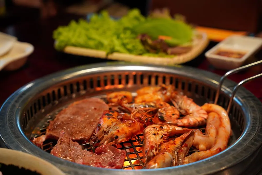 Grilled shrimp and beef sizzling on a Korean barbecue grill